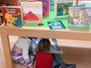 Alcuni bambini giocano sotto un tavolo della Biblioteca Monticone di Canelli